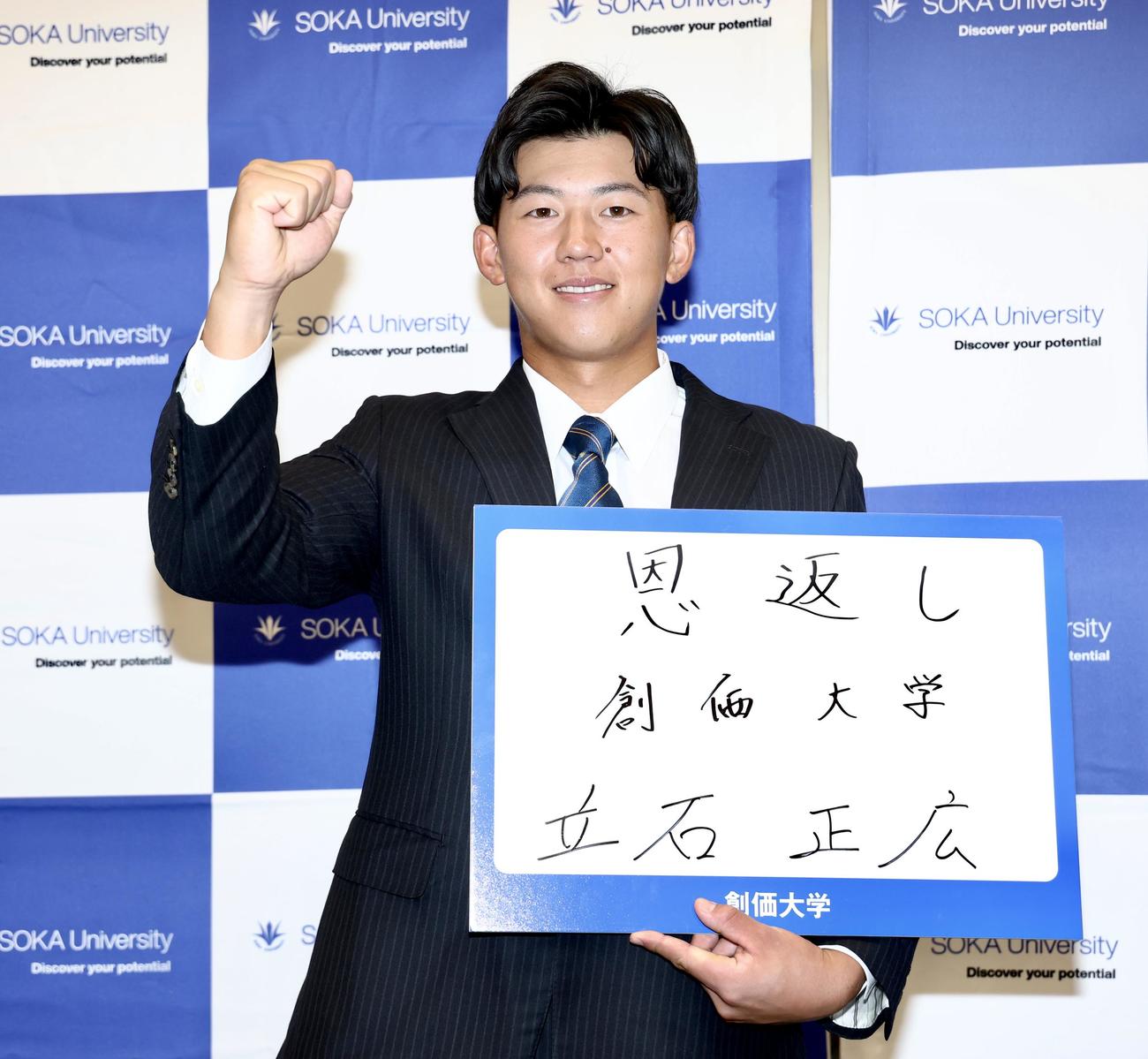 「恩返し」としたためたボードを手に写真に納まる創価大・立石（撮影・河田真司）