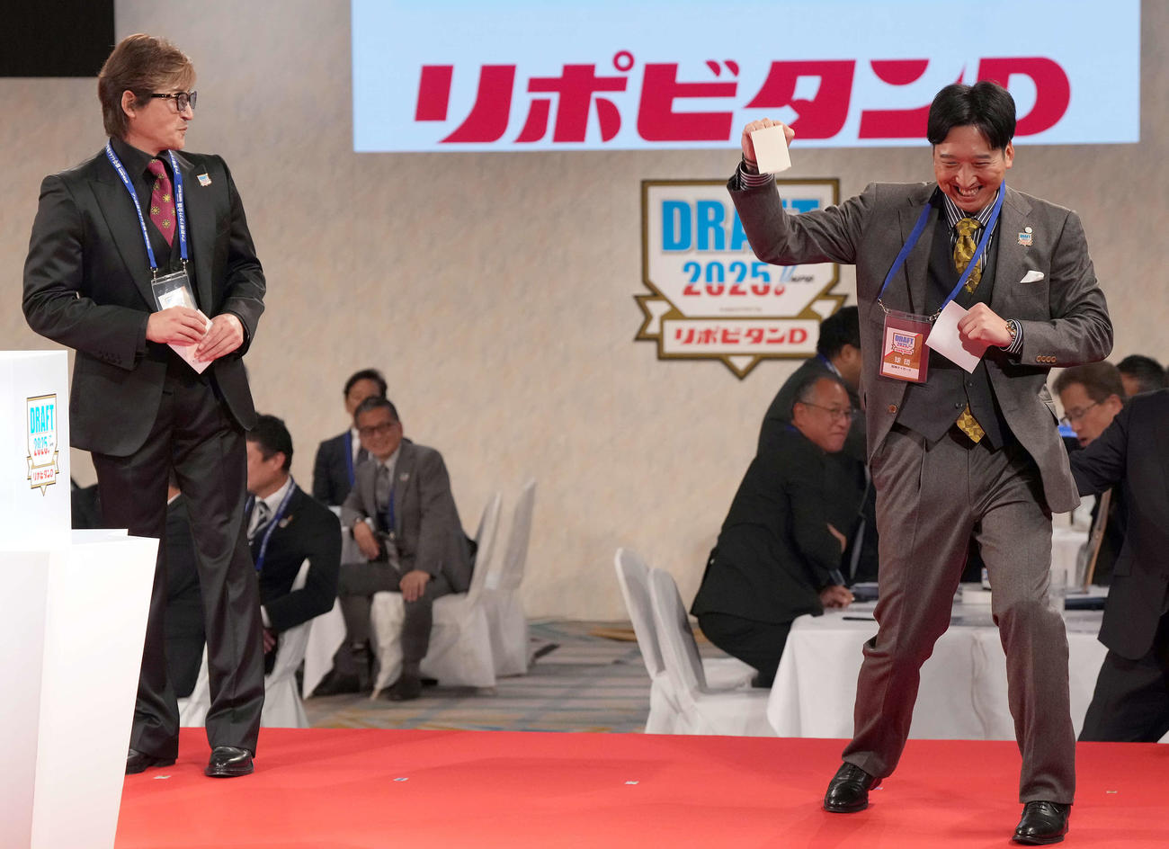23日、3球団が競合、創価大・立石の交渉権を獲得しポーズを決める阪神藤川監督。左は日本ハム新庄監督