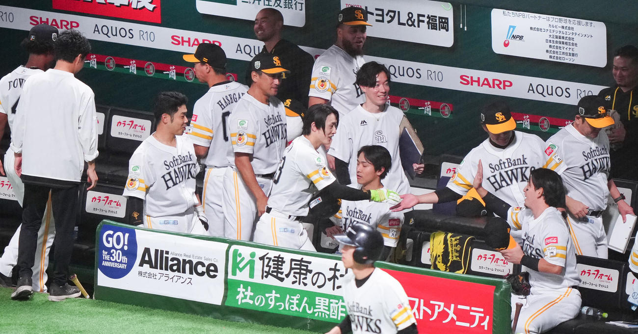 ソフトバンク対阪神　7回裏に1試合5安打の日本シリーズ新記録を達成したソフトバンク周東（中央）はベンチでタッチを交わす（撮影・鈴木みどり）