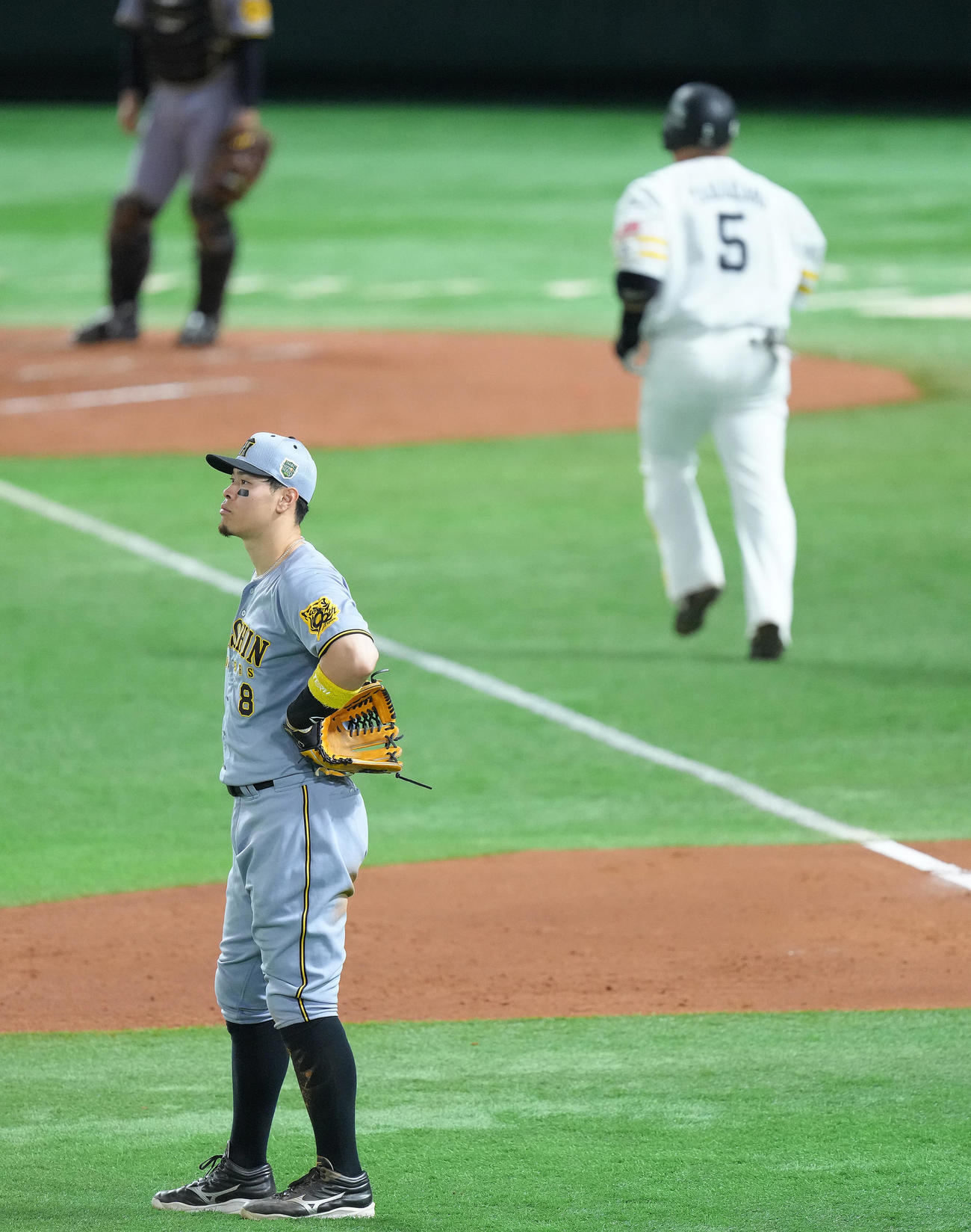 ソフトバンク対阪神　2回裏ソフトバンク2死一、二塁、山川（後方）の3点本塁打に厳しい表情を見せる佐藤輝（撮影・足立雅史）
