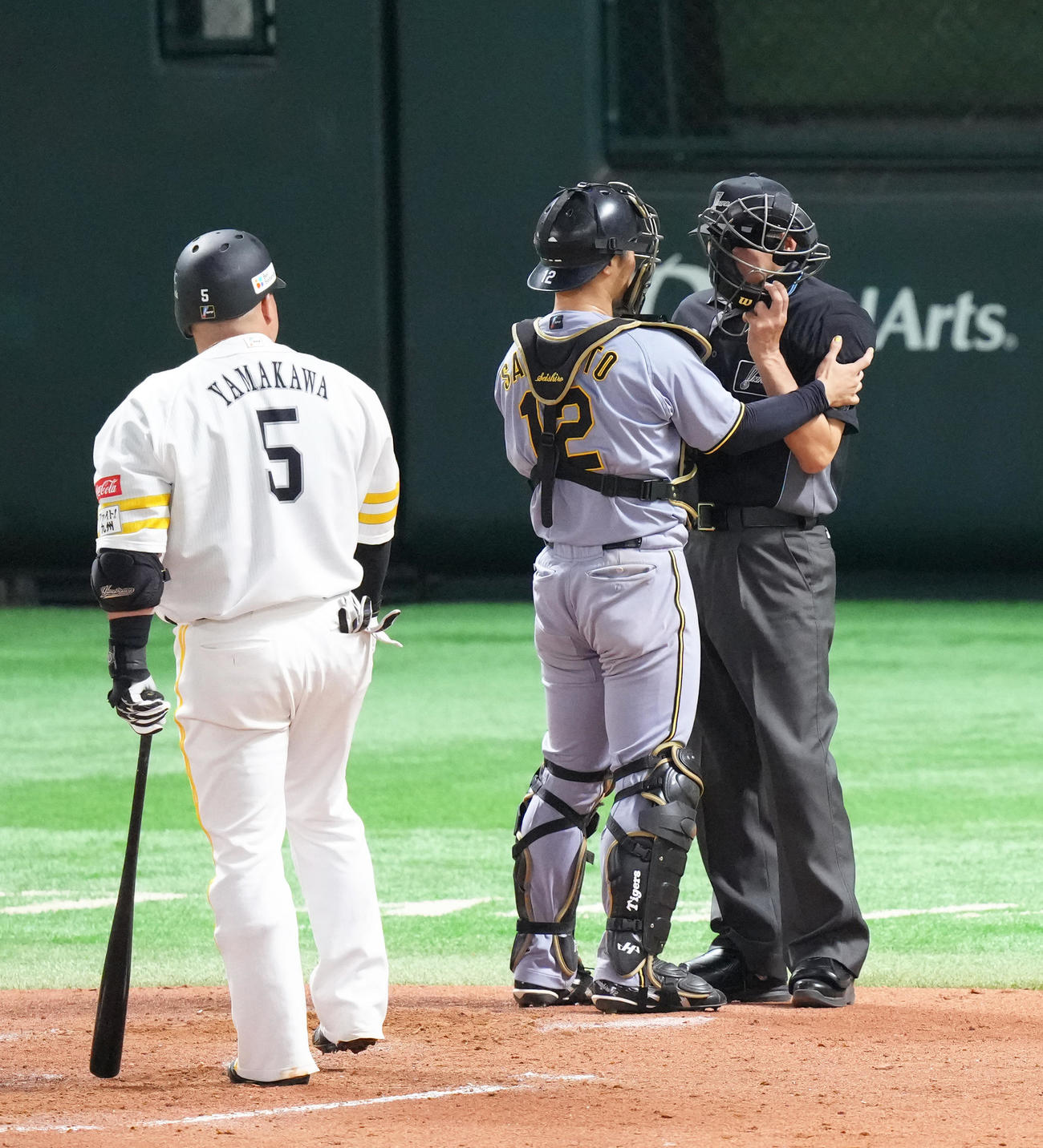 ソフトバンク対阪神　4回裏ソフトバンク1死、山川（左）のファウルボールの打球が当たった有隅球審を心配する捕手坂本（撮影・足立雅史）