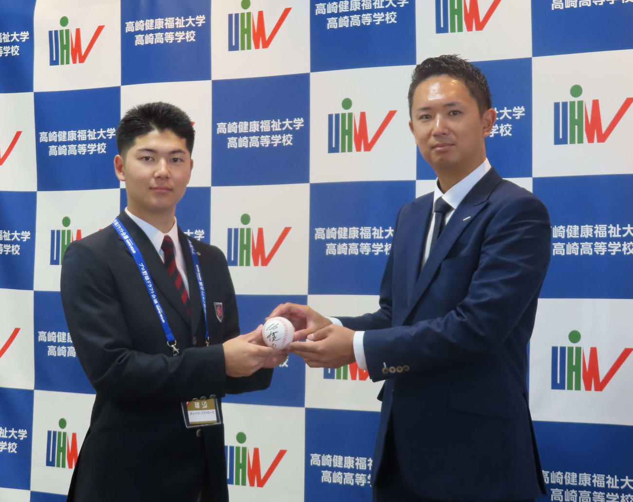 オリックス岸田監督の直筆サインが入ったボールを担当の岡崎スカウト（右）から手渡される健大高崎・佐藤（撮影・山本佳央）