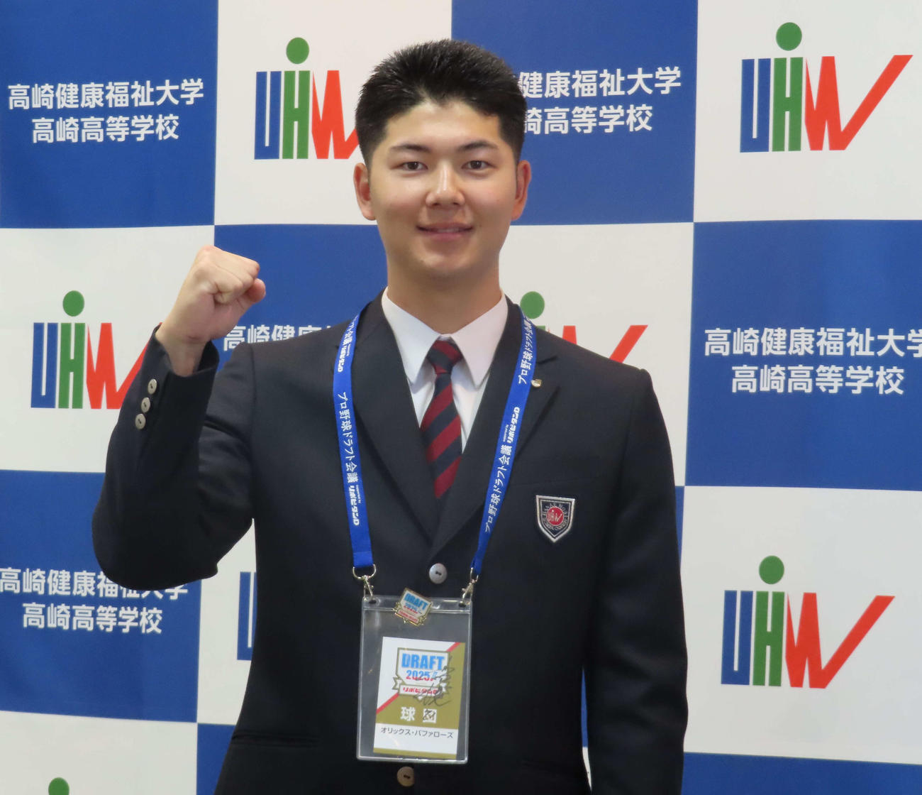 オリックス岸田監督の直筆サインが入ったパスを首にかけガッツポーズをする健大高崎・佐藤（撮影・山本佳央）