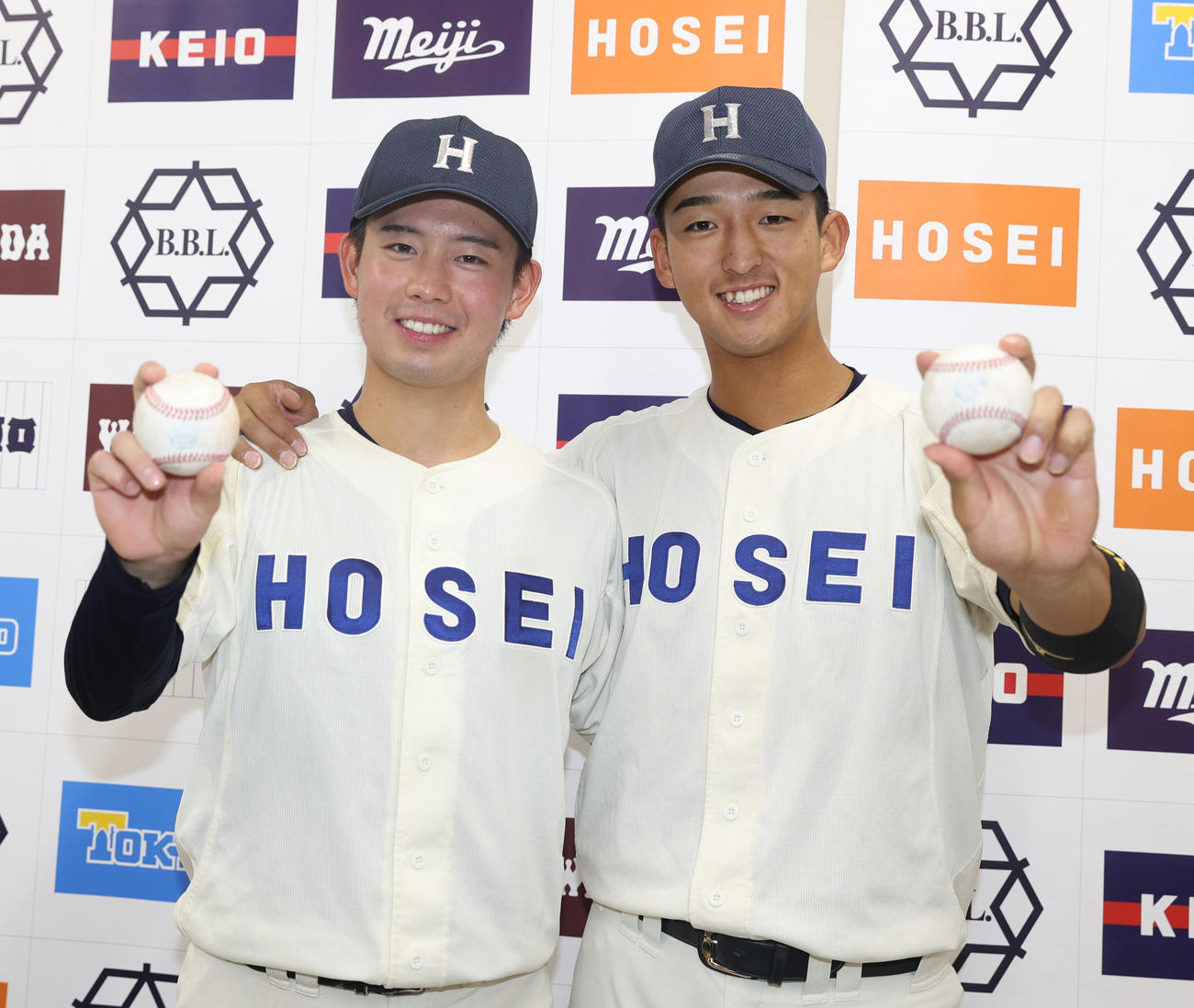 東大対法大　完封勝利を挙げた法大・野崎（左）と本塁打の松下はボールを持ち笑顔を見せる（撮影・柴田隆二）