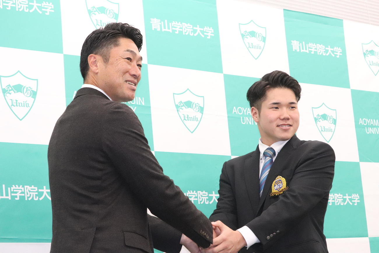 指名あいさつを受けたDeNAドラフト1位の青学大・小田は笑顔で相川監督と握手（撮影・小早川宗一郎）