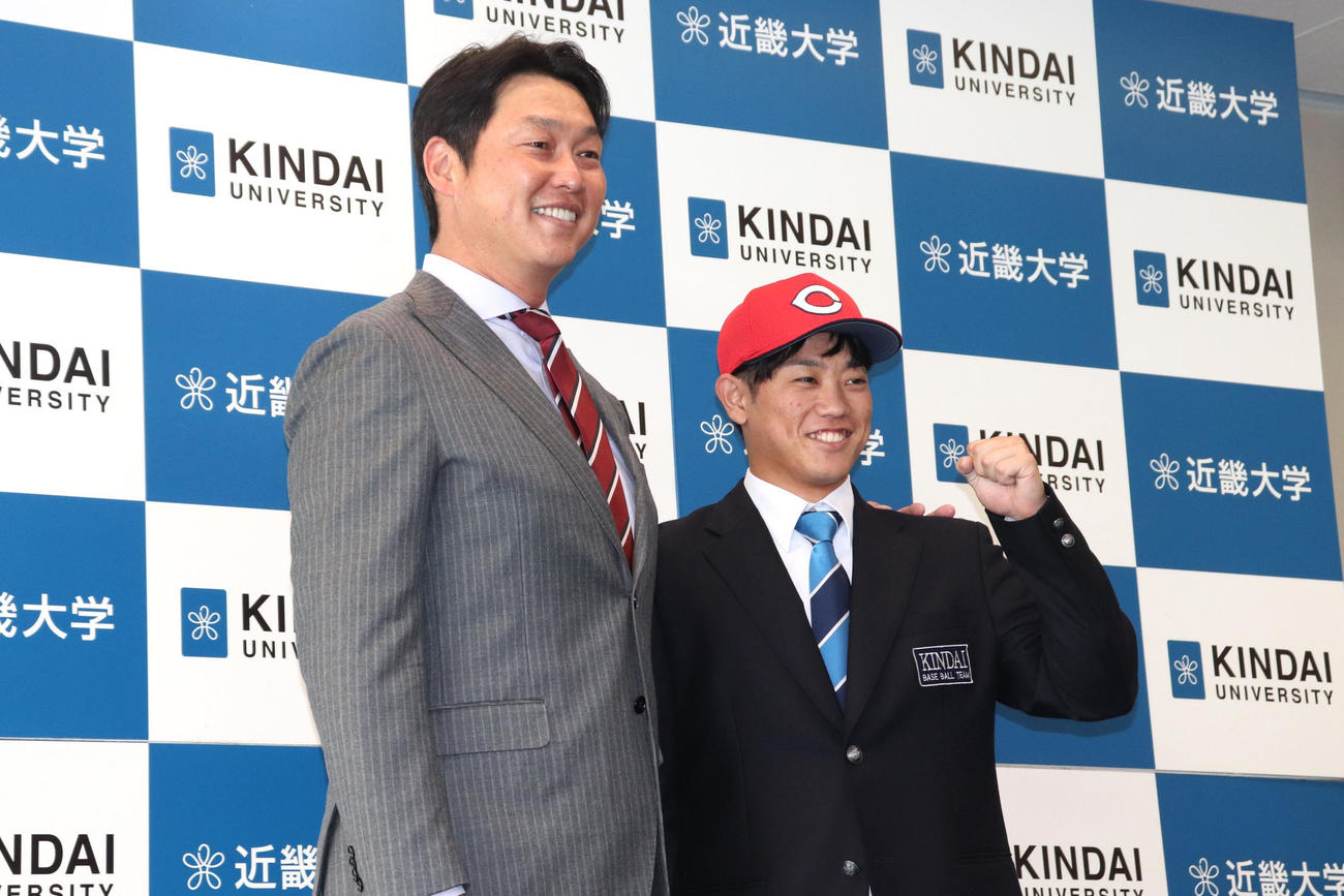 指名あいさつに訪れた広島・新井貴浩監督とガッツポーズで写真に収まる、同3位の近大・勝田（撮影・中島麗）