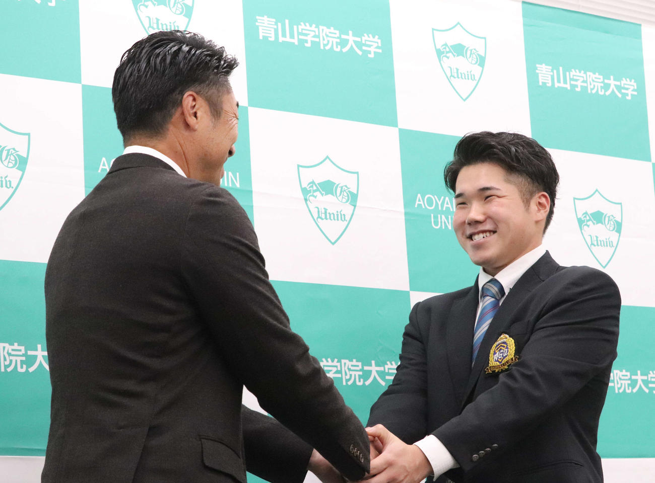 指名あいさつを受けたDeNAドラフト1位の青学大・小田は笑顔で相川監督と握手（撮影・小早川宗一郎）
