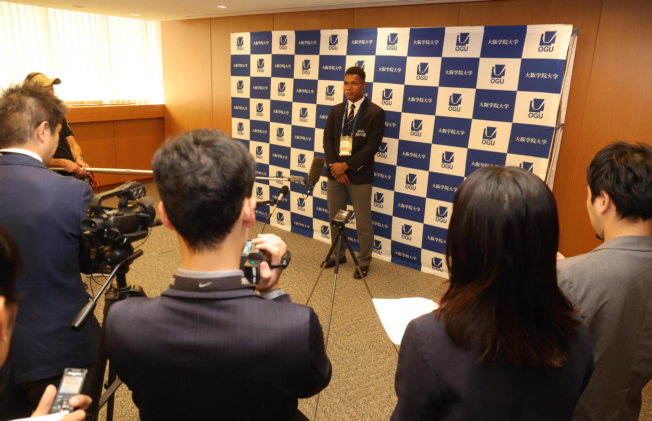 日本ハムからの指名あいさつを終えて囲み取材を受ける大阪学院大エドポロ　ケイン（中央）（撮影・白石智彦）