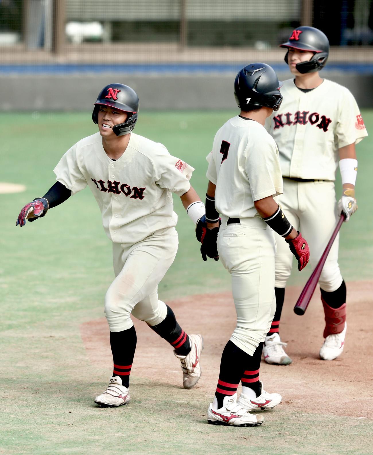 専大対日大　1回裏日大1死満塁、富津の先制2点適時打で生還する谷端（左）（撮影・河田真司）