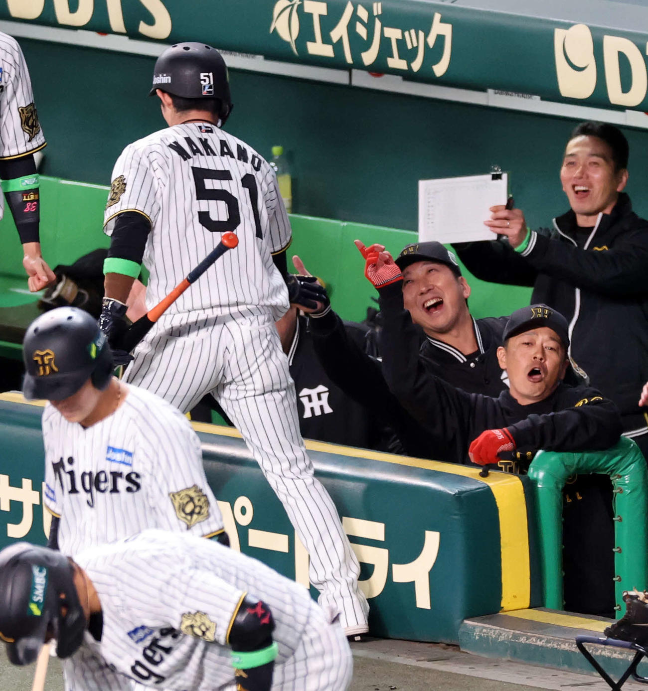 阪神対ソフトバンク　1回裏阪神2死一塁、佐藤輝の先制二塁打で生還した中野（手前）を笑顔で迎える藤川監督ら（撮影・浅見桂子）