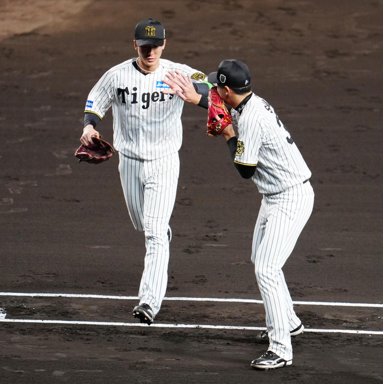 阪神対ソフトバンク　2回表終了後、タッチを交わす阪神先発才木（右）と遊撃手小幡（撮影・江口和貴）
