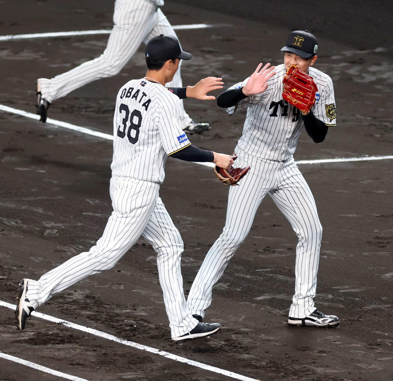 阪神対ソフトバンク　2回表ソフトバンク1死一塁、今宮を併殺に仕留めた才木（右）は小幡と笑顔でハイタッチ（撮影・浅見桂子）