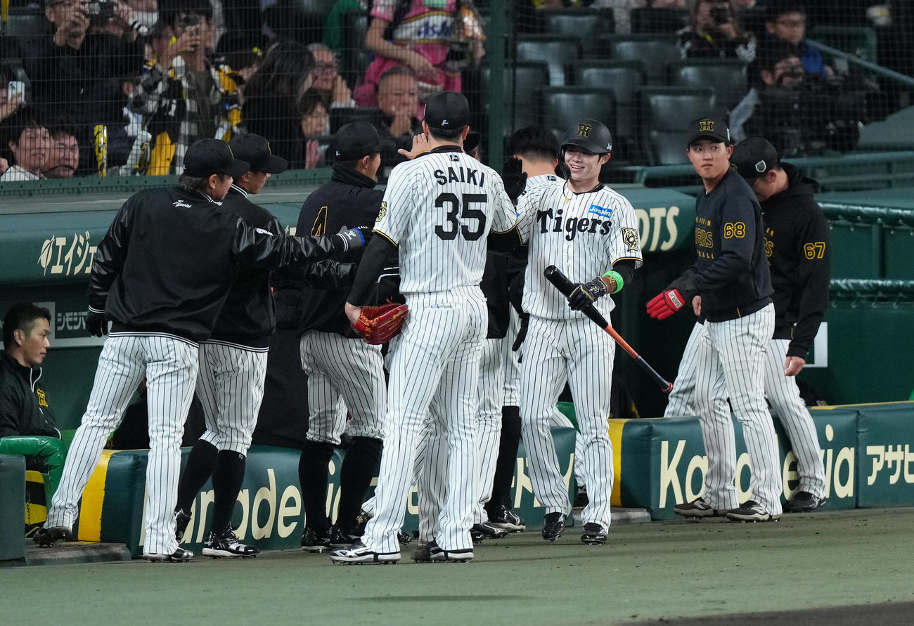 阪神対ソフトバンク　1回裏阪神2死一塁、佐藤輝の先制適時二塁打で生還した中野（中央右）は才木とタッチを交わす（撮影・足立雅史）