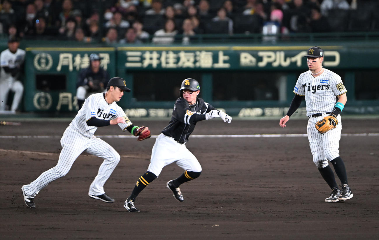 阪神対ソフトバンク　5回表ソフトバンク無死二塁、海野の一ゴロで二、三塁間にはさまれタッチアウトとなる牧原大、左は小幡（撮影・和賀正仁）