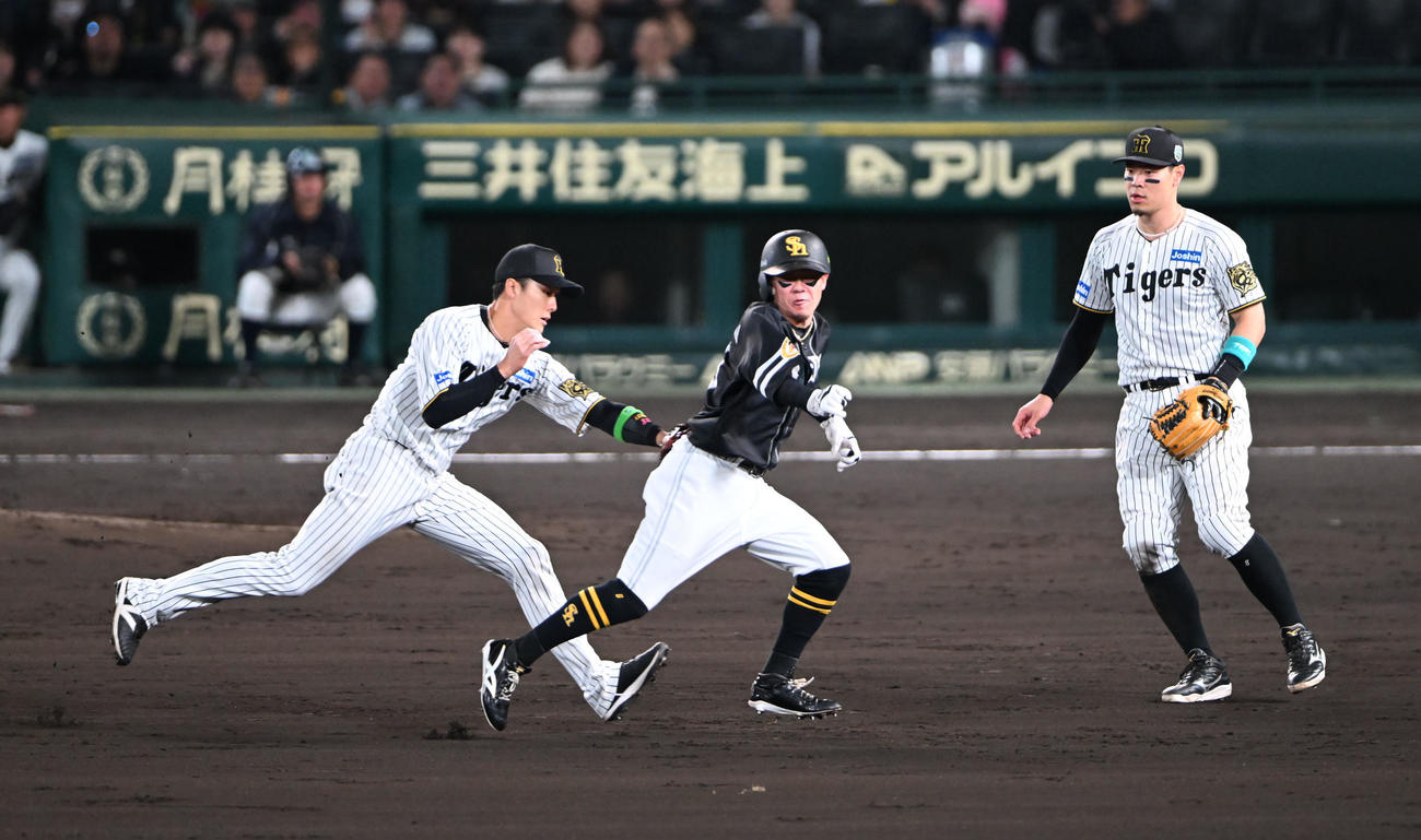 阪神対ソフトバンク　5回表ソフトバンク無死二塁、海野の一ゴロで二、三塁間にはさまれタッチアウトとなる牧原大、左は小幡（撮影・和賀正仁）