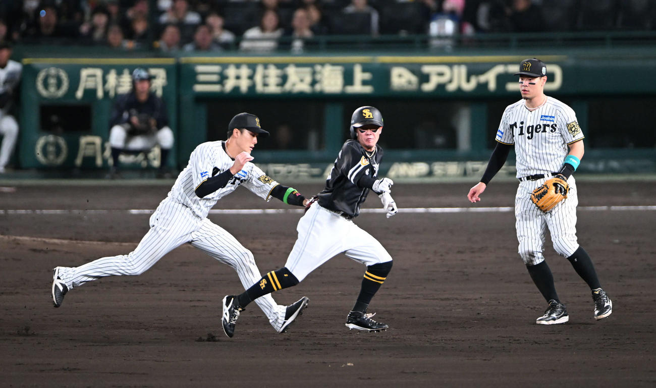 阪神対ソフトバンク　5回表ソフトバンク無死二塁、海野の一ゴロで二、三塁間にはさまれタッチアウトとなる牧原大、左は小幡（撮影・和賀正仁）