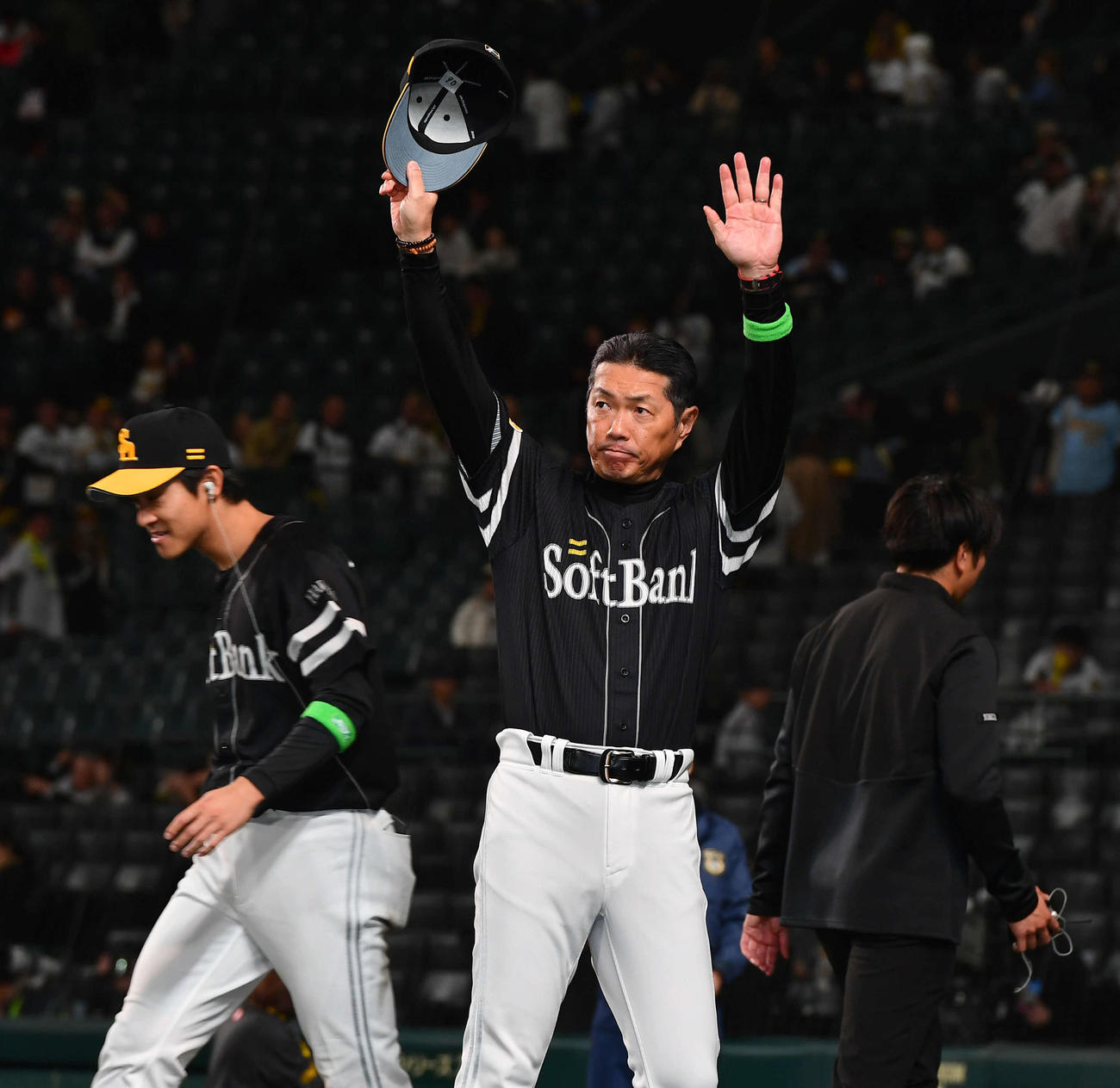 阪神対ソフトバンク　勝利監督インタビューを終え、ファンに手を振りながら引き揚げるソフトバンク小久保監督（右）。左はヒーローインタビューへ向かう柳町（撮影・岩下翔太）