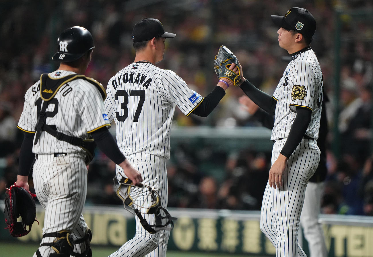 阪神対ソフトバンク　6回表を終えベンチへ戻る及川（中央）を迎える阪神才木（右）（撮影・鈴木みどり）