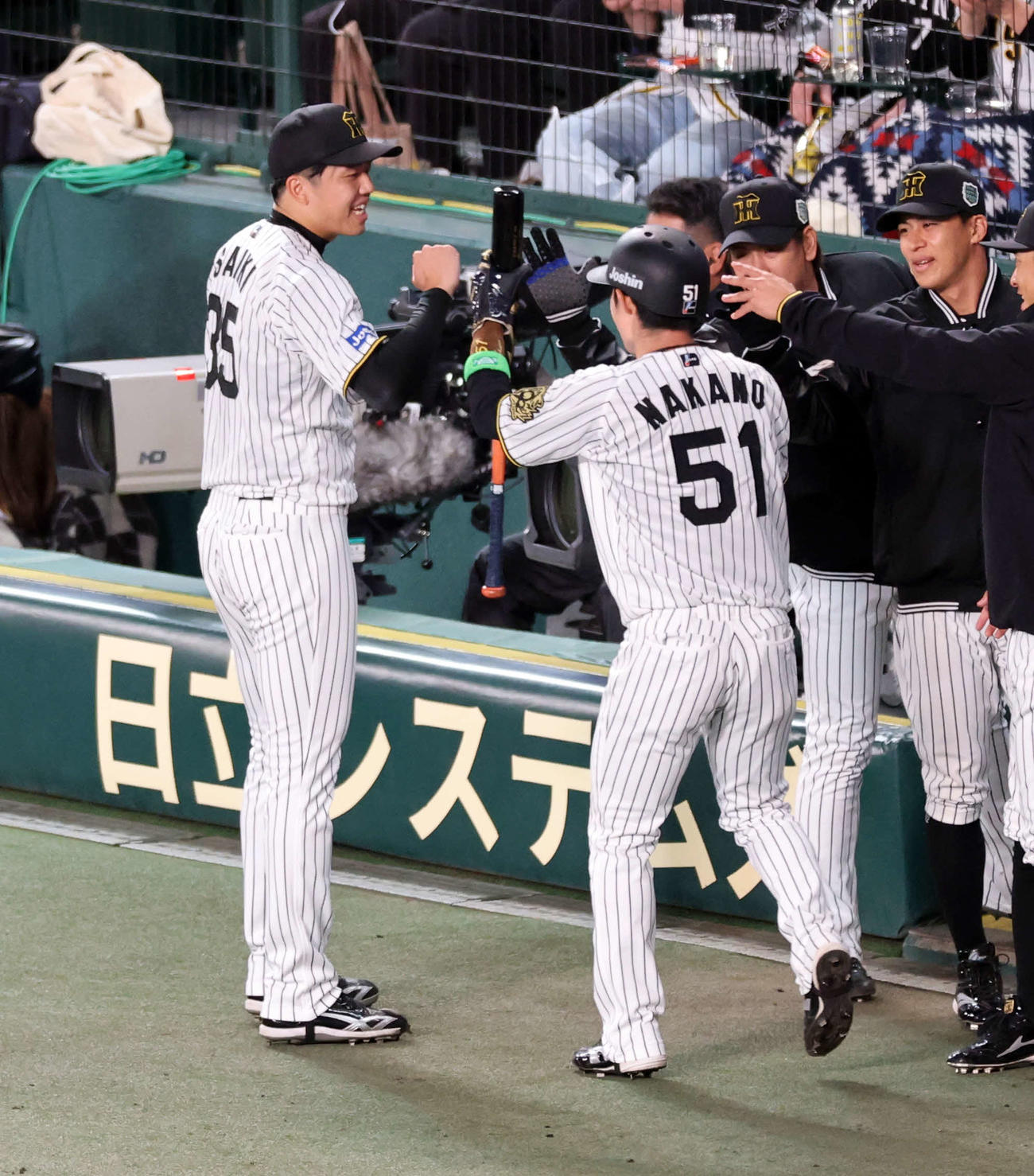 阪神対ソフトバンク　1回裏阪神2死一塁、佐藤輝の先制二塁打で生還した中野（手前）を笑顔で迎える才木（奥）（撮影・浅見桂子）