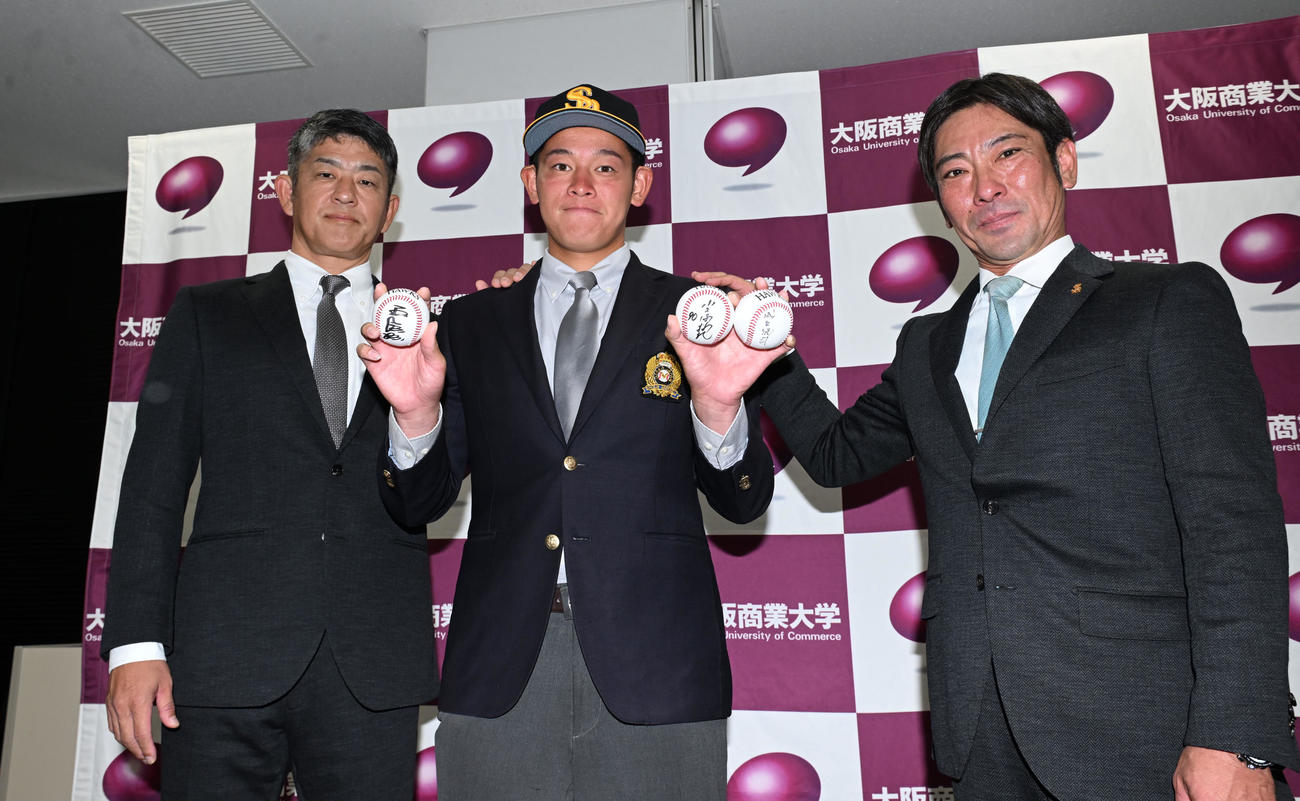 ソフトバンクから3位指名され、福山スカウトチーフ（左）、稲嶺スカウト（右）からあいさつを受ける大商大・鈴木（撮影・和賀正仁）