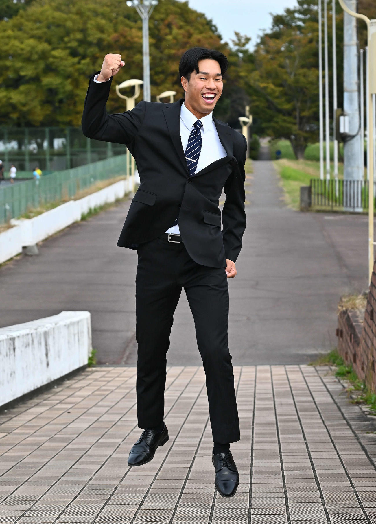指名あいさつを受けた阪神ドラフト3位の筑波大・岡城は跳び上がってガッツポーズする（撮影・滝沢徹郎）