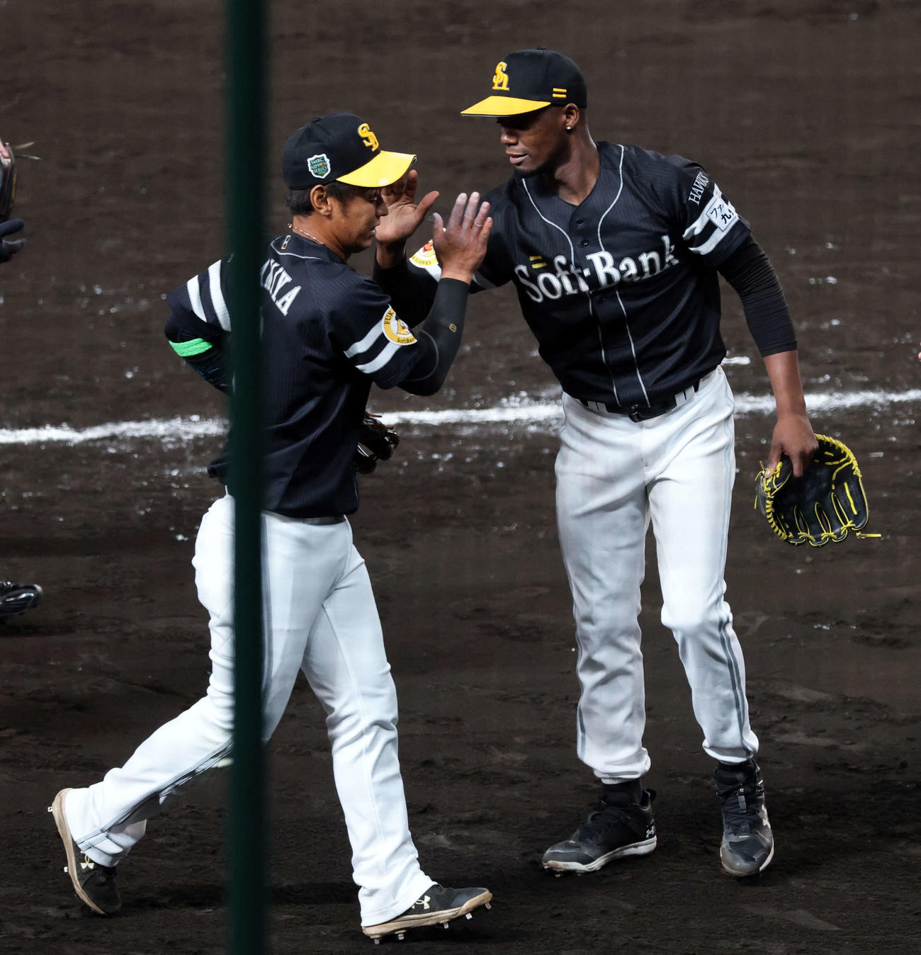 2025年10月28日　阪神対ソフトバンク　6回裏阪神2死一、二塁、坂本の打球を好捕した今宮（左）をハイタッチで迎えるモイネロ