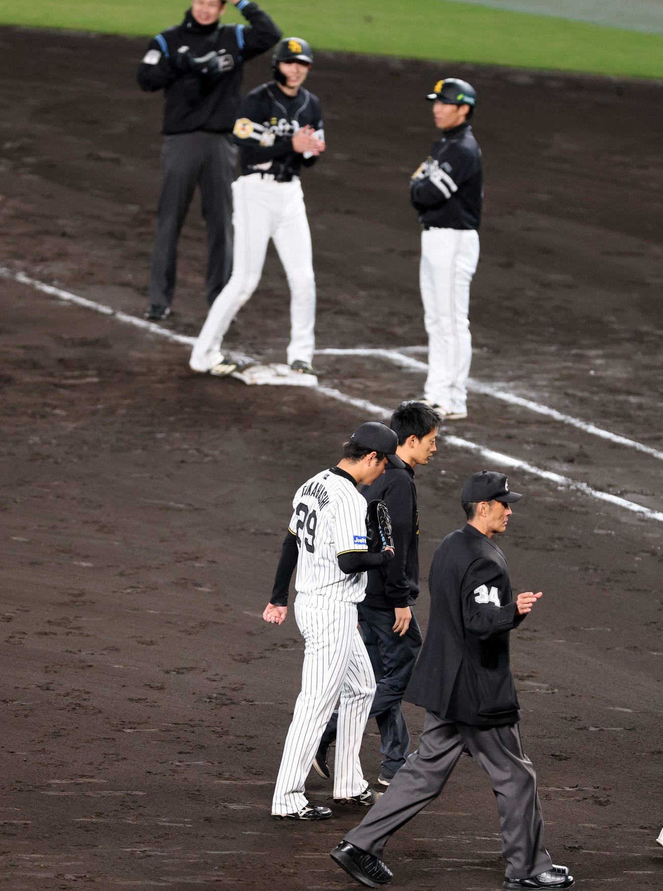 阪神対ソフトバンク　5回表ソフトバンク1死一、二塁、周東（上）の投手強襲打を受けた高橋（下）は治療でマウンド降りる（撮影・浅見桂子）