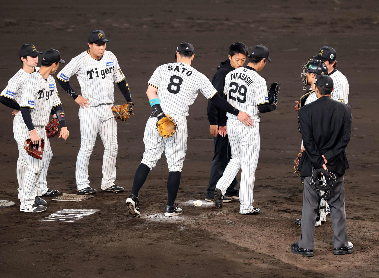 阪神対ソフトバンク　5回表ソフトバンク1死一、二塁、周東の投手強襲打を受けた高橋（背番号29）は佐藤輝に腰をたたかれながら治療でマウンド降りる（撮影・浅見桂子）
