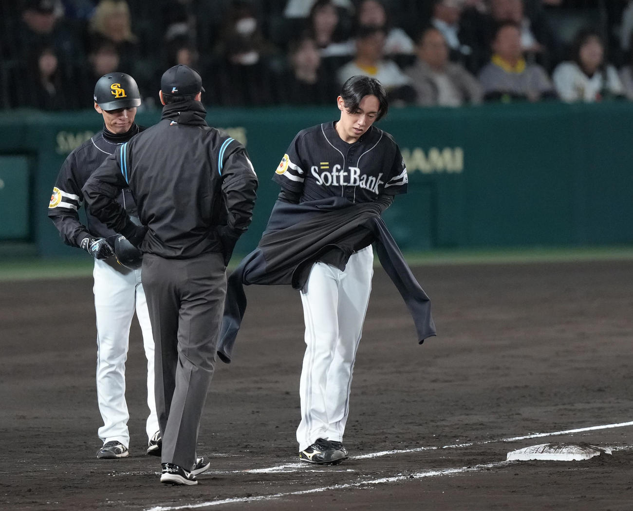 阪神対ソフトバンク　5回表ソフトバンク1死、大津は四球で出塁し塁上でジャンパーを着る（撮影・足立雅史）