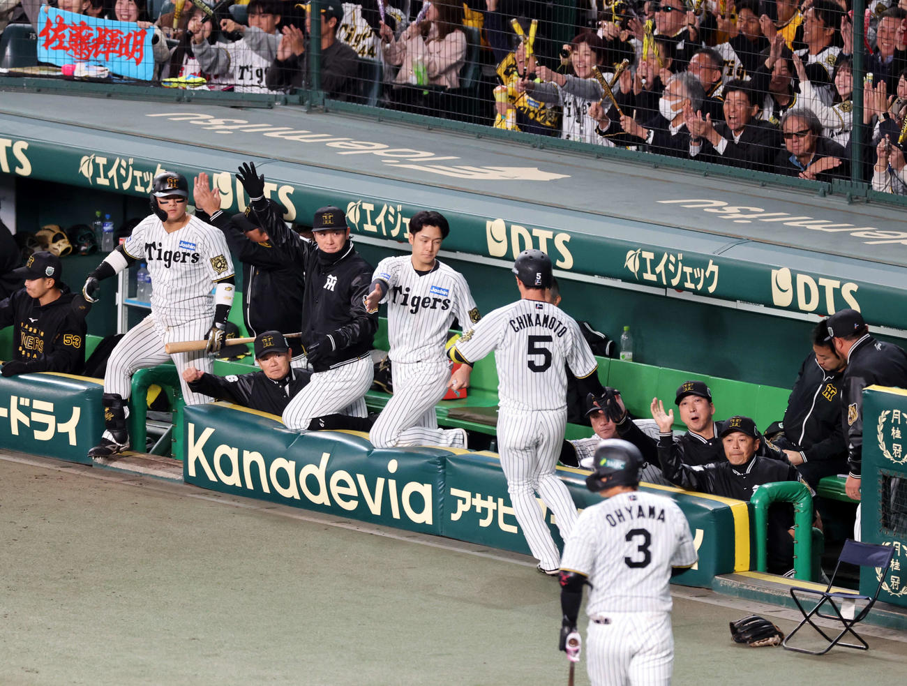 阪神対ソフトバンク　8回裏阪神1死一、二塁、佐藤輝の適時打で生還した近本（手前）を迎える藤川監督（右から3人目）ら阪神の選手たち（撮影・浅見桂子）