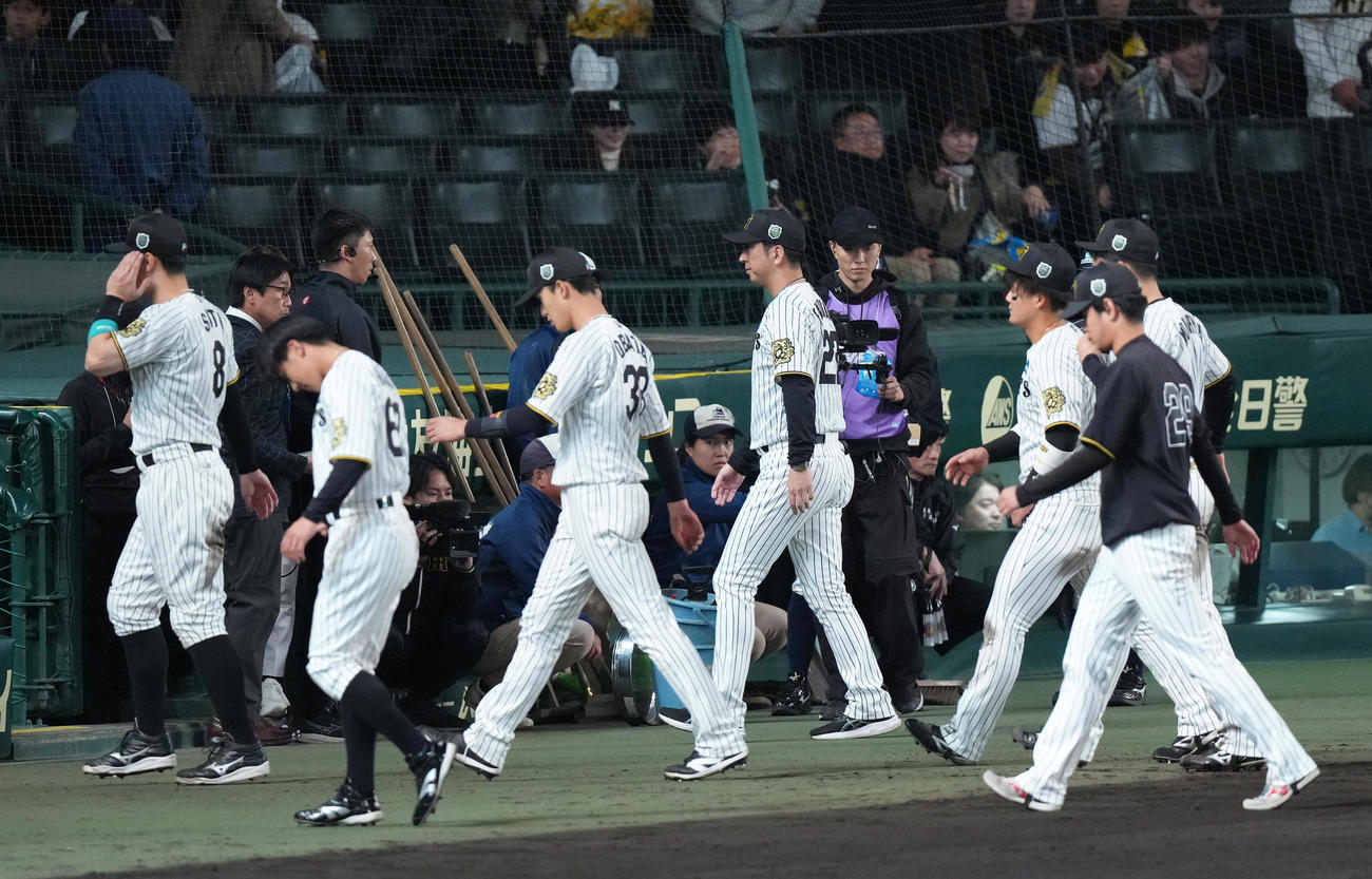 阪神対ソフトバンク　ソフトバンクに連敗し引き揚げる阪神藤川監督（中央右）ら（撮影・足立雅史）