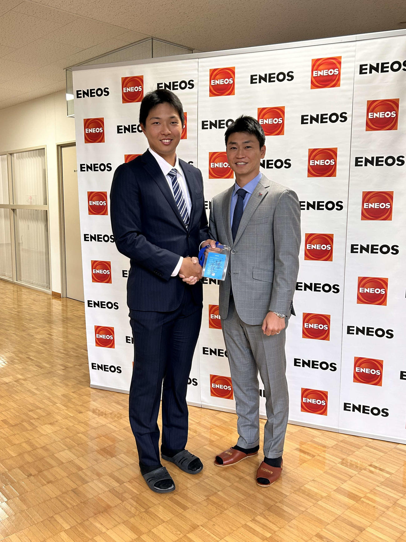 笑顔で写真に納まるヤクルトからドラフト7位指名を受けたENEOS・飯田（左）とヤクルト青木GM特別補佐（撮影・上田悠太）