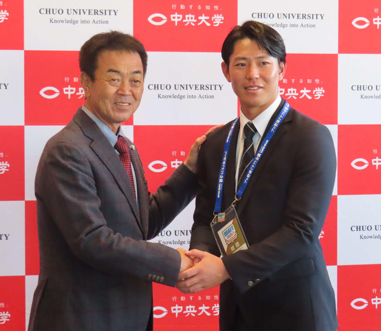 水野編成本部長代理スカウト担当と握手を交わす巨人ドラフト4位の皆川（撮影・水谷京裕）