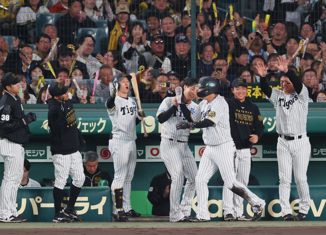阪神対ソフトバンク　2回裏阪神2死一、二塁、坂本の左前適時打で生還し、祝福を受ける二走大山（手前）（撮影・上山淳一）