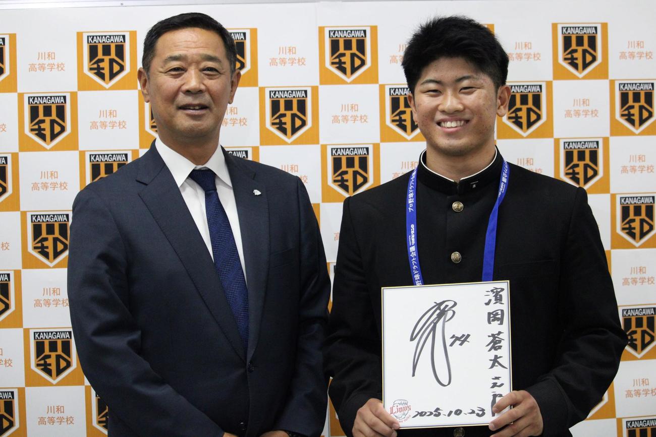 西口監督のサインを持つ西武育成4位の川和・浜岡（右）と指名あいさつに訪れた秋元副本部長（撮影・金子真仁）