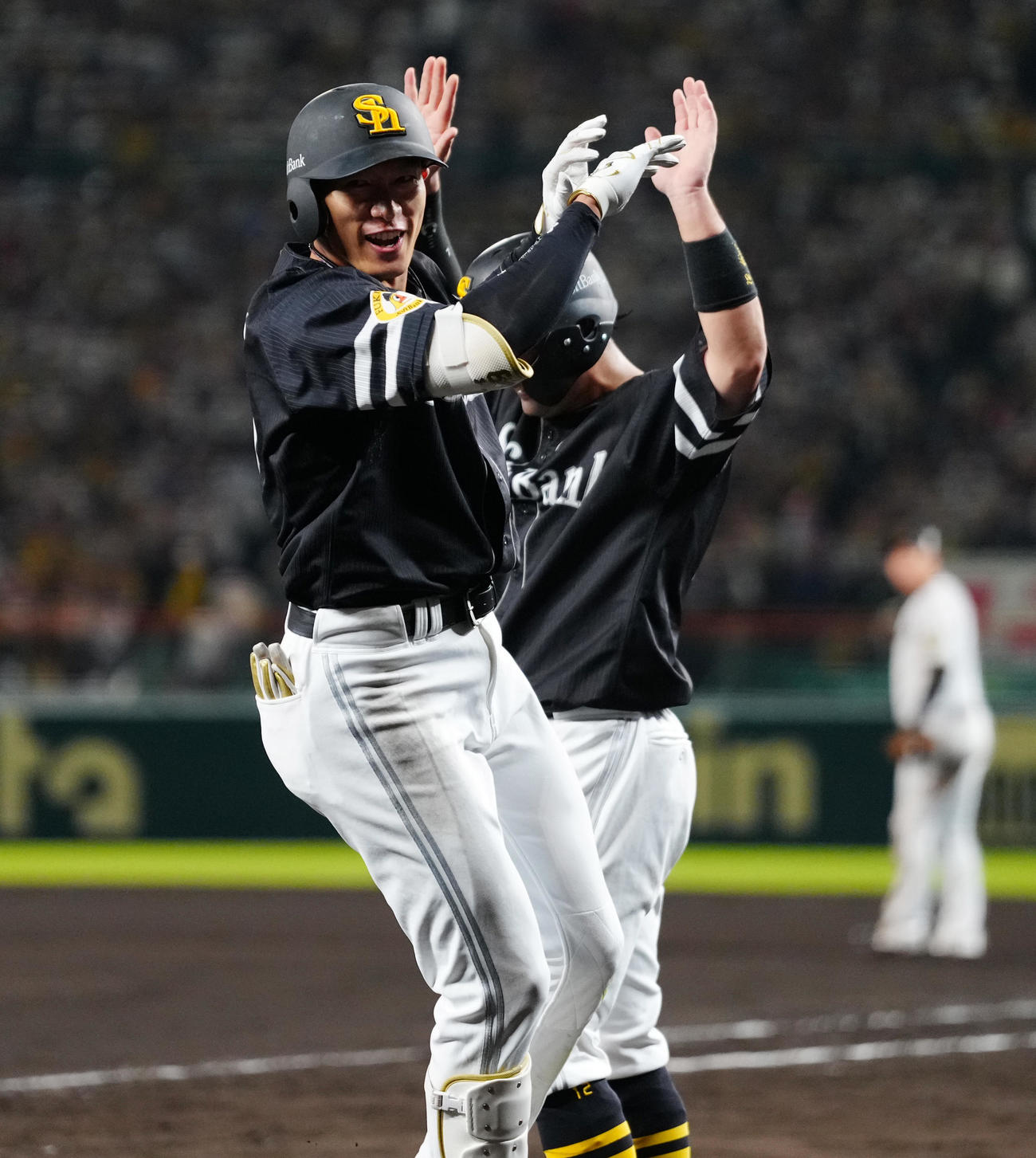阪神対ソフトバンク　8回表ソフトバンク1死一塁、左越え2点本塁打を放った柳田は生還し、笑顔で嶺井（後方）とハイタッチ（撮影・鈴木みどり）