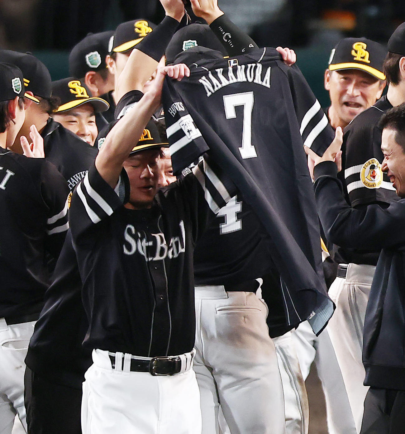 阪神対ソフトバンク　阪神を破り日本一を達成し、中村のユニホームを掲げる牧原大（撮影・前田充）