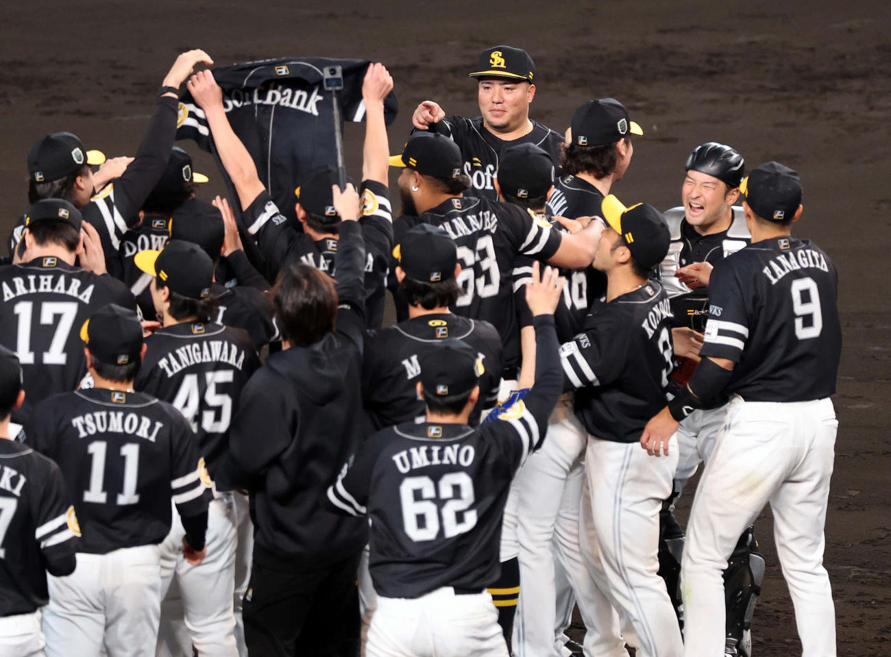 阪神対ソフトバンク　日本一を決め喜びの輪の中の中村晃のユニホームを冷静に指さすソフトバンク山川（後方）（撮影・浅見桂子）