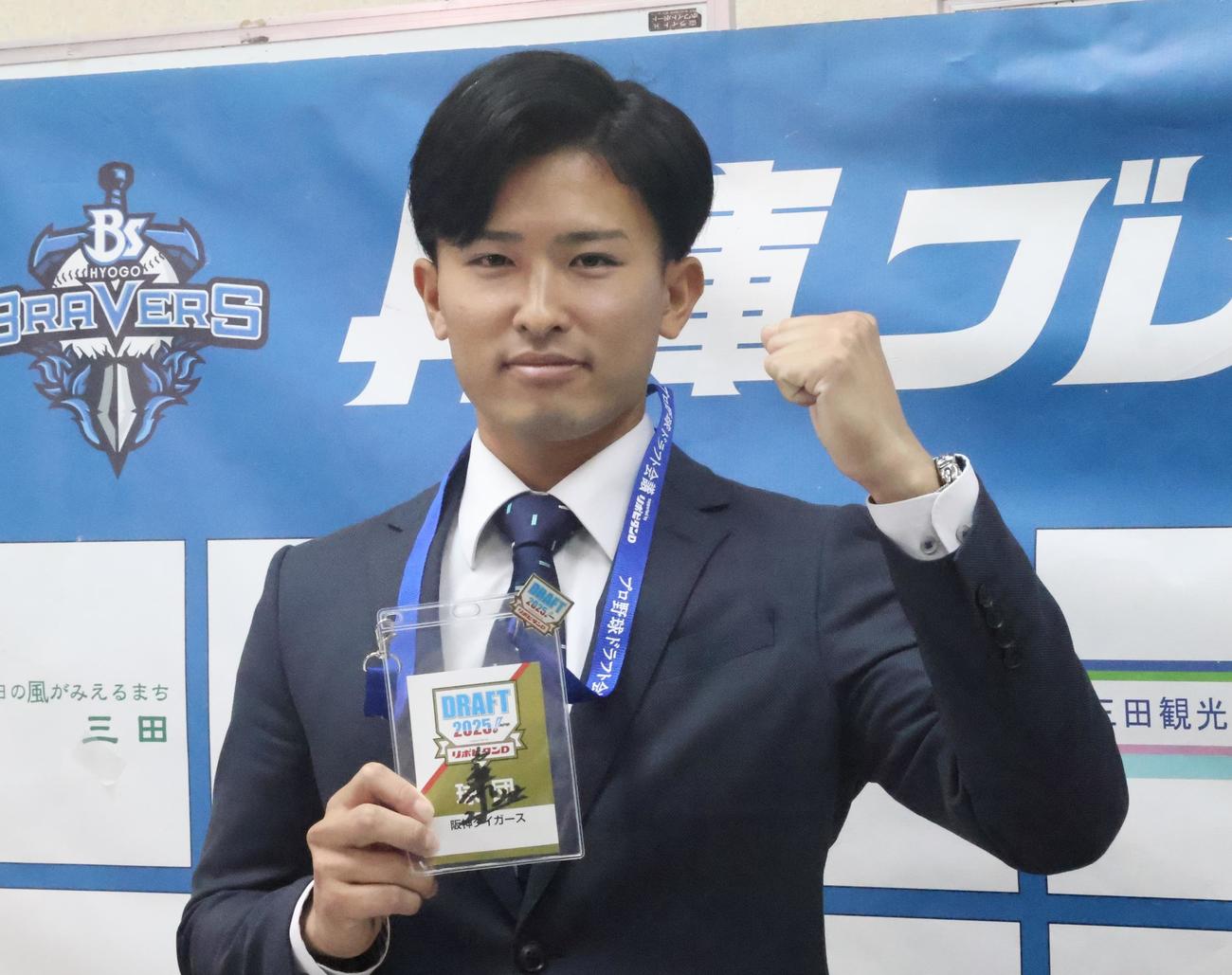 阪神藤川球児監督のサインが入ったドラフト会議2025のIDを持ち、ガッツポーズする育成ドラフト2位の関西独立リーグ・兵庫の山崎（撮影・塚本光）