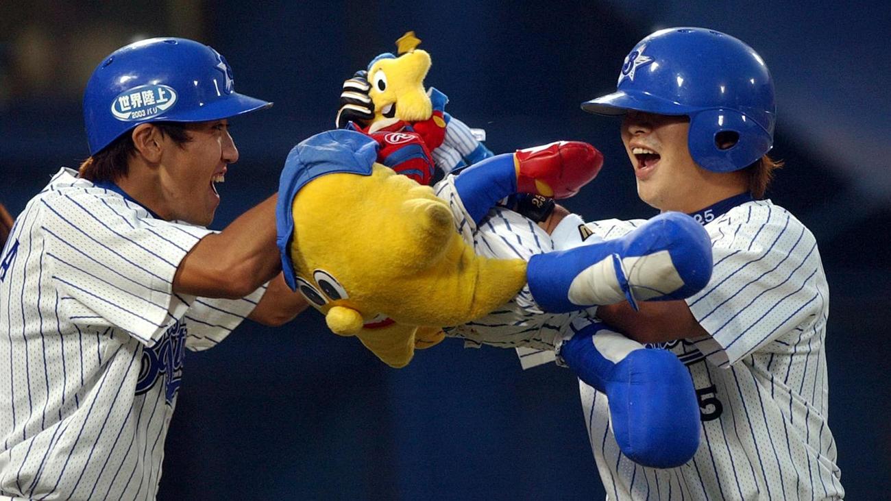ハイタッチする現役時代の相川監督（左）と村田コーチ（2003年撮影）