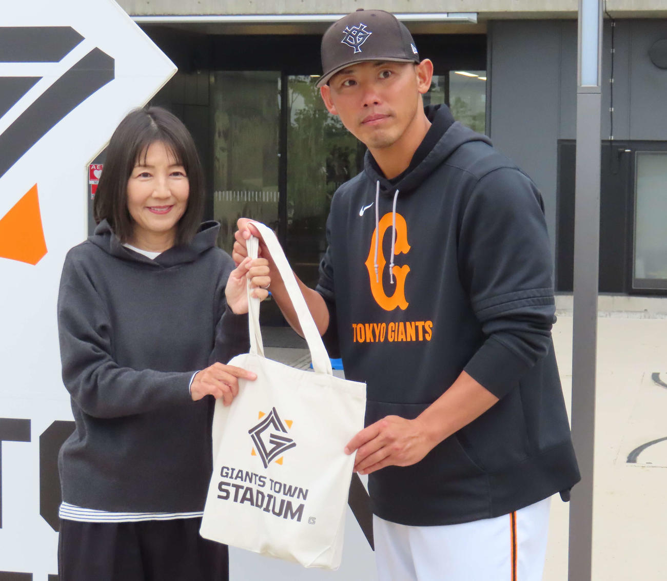 ジャイアンツタウンスタジアム来場20万人目の来場者に記念品を贈呈した矢野巡回打撃コーチ（撮影・水谷京裕）