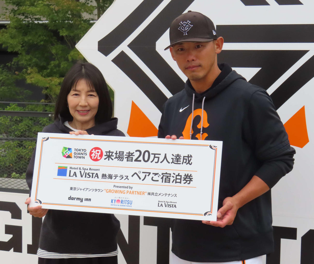 ジャイアンツタウンスタジアム来場20万人目の来場者に記念品を贈呈した矢野巡回打撃コーチ（撮影・水谷京裕）