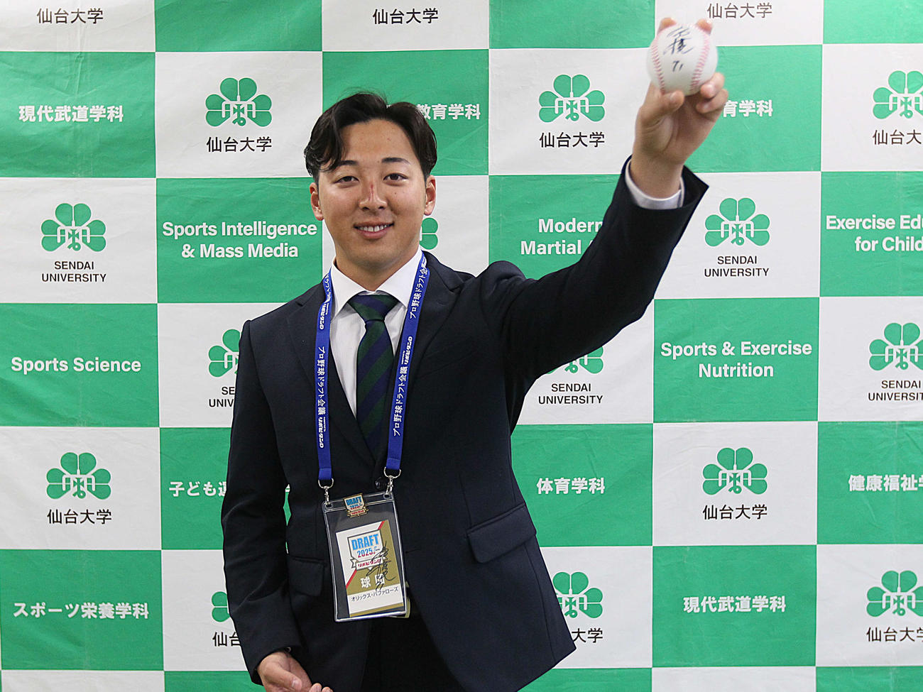 オリックス岸田監督のサイン入りボールを片手に笑顔でフォームをみせる仙台大・渡辺（撮影・高橋香奈）