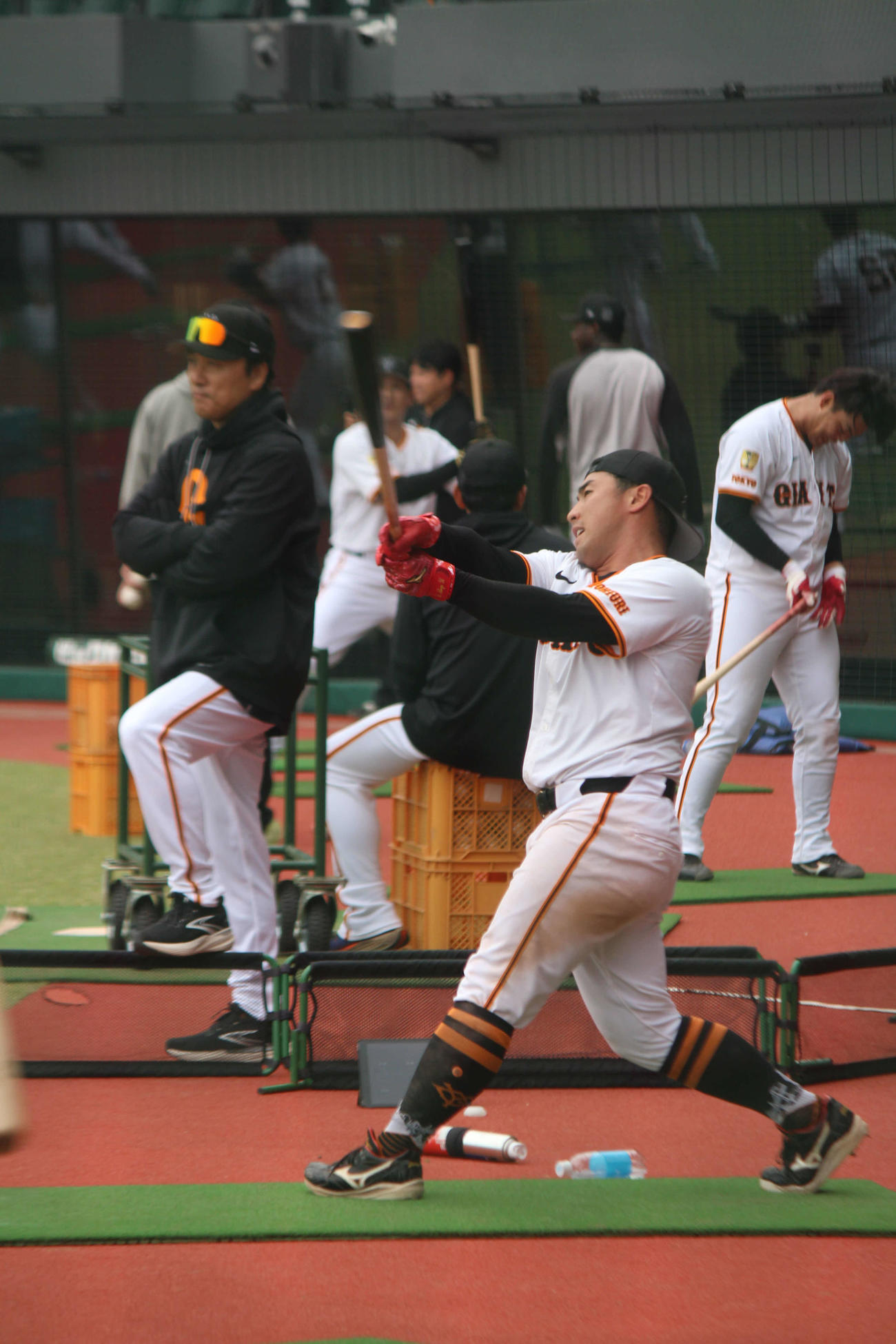 浅野の打球の行方を見つめる李承燁・臨時コーチ（左）