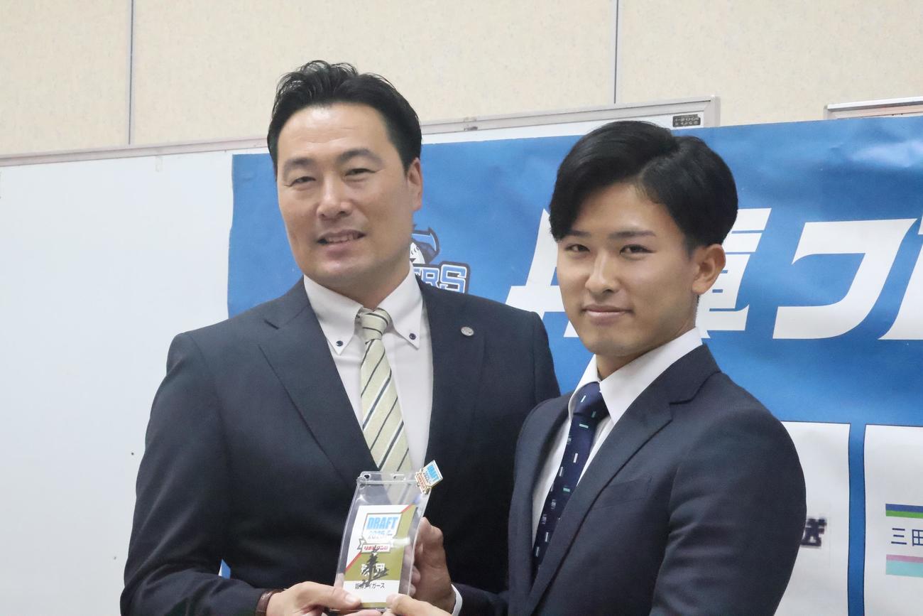 阪神藤川監督のサインが入ったドラフト会議2025のIDを筒井スカウト（左）と持つ、育成ドラフト2位の関西L兵庫の山崎（撮影・塚本光）