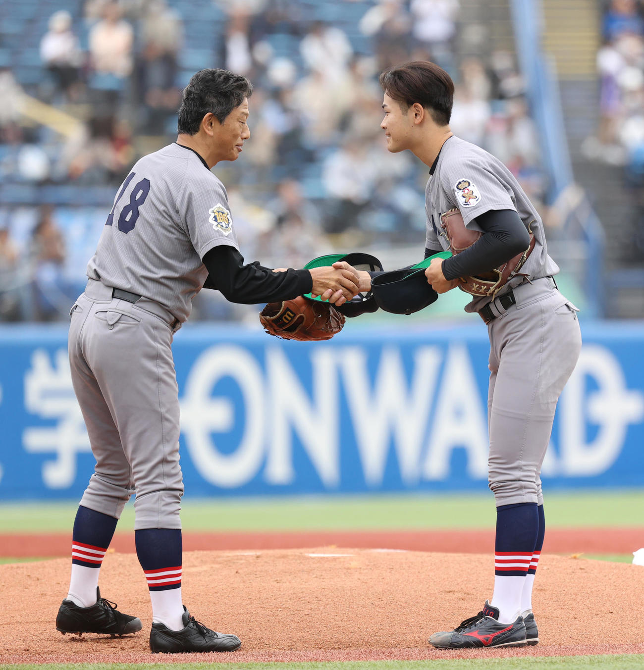 早大対慶大　始球式を務めた慶大OBの志村亮氏（左）は慶大・渡辺和と握手する（撮影・柴田隆二）