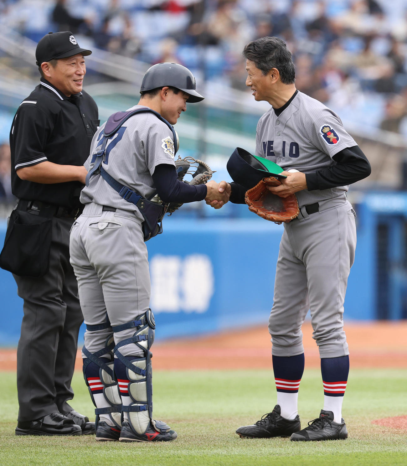 早大対慶大　始球式を務めた慶大OBの志村亮氏（右）は慶大・吉開捕手と握手する（撮影・柴田隆二）