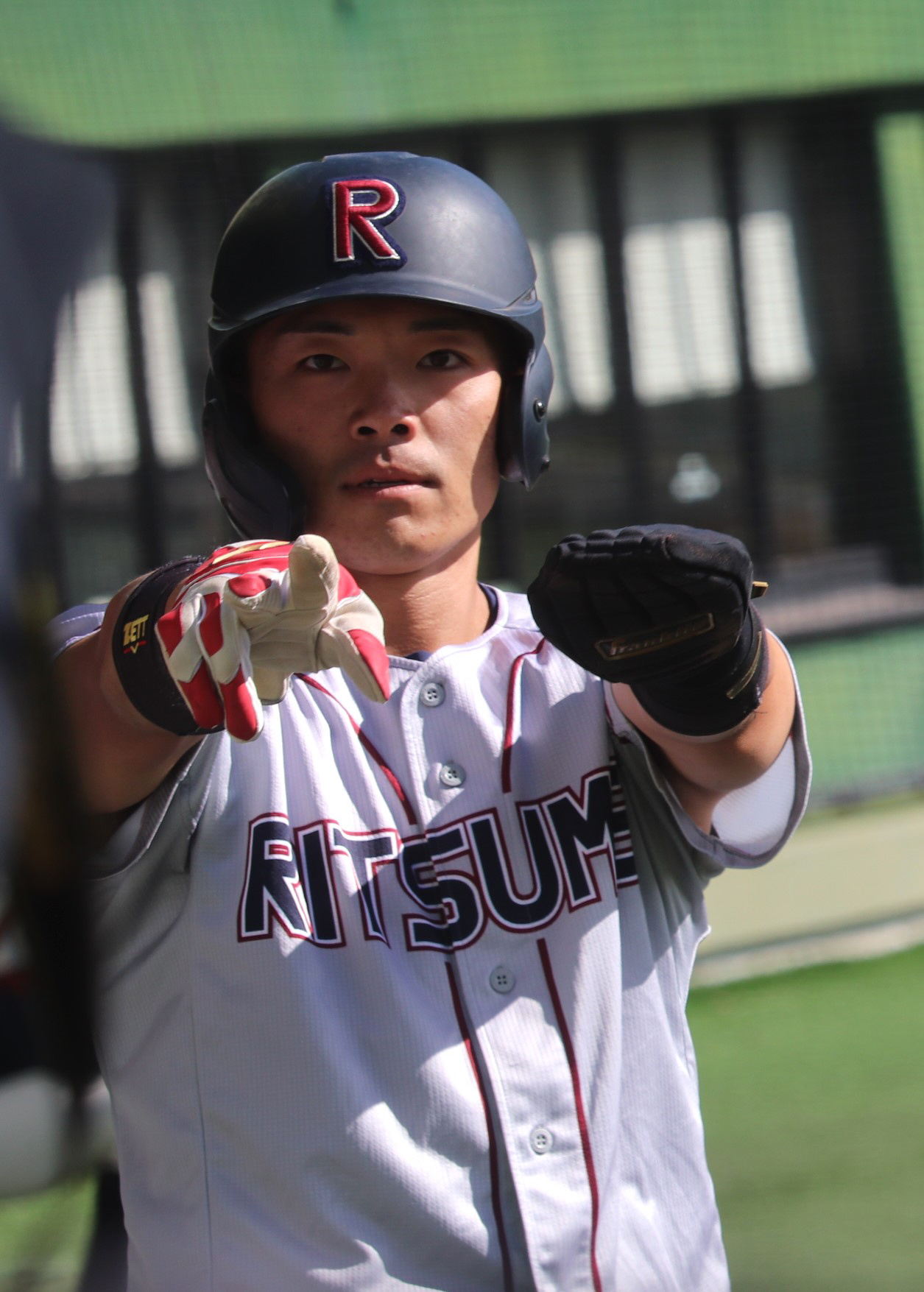 奈良学園大対立命大　2回1死二塁で立命大7番の福井の左前適時打で二塁から本塁に生還し、ベンチ前でポーズを決める角井（撮影・中島麗）