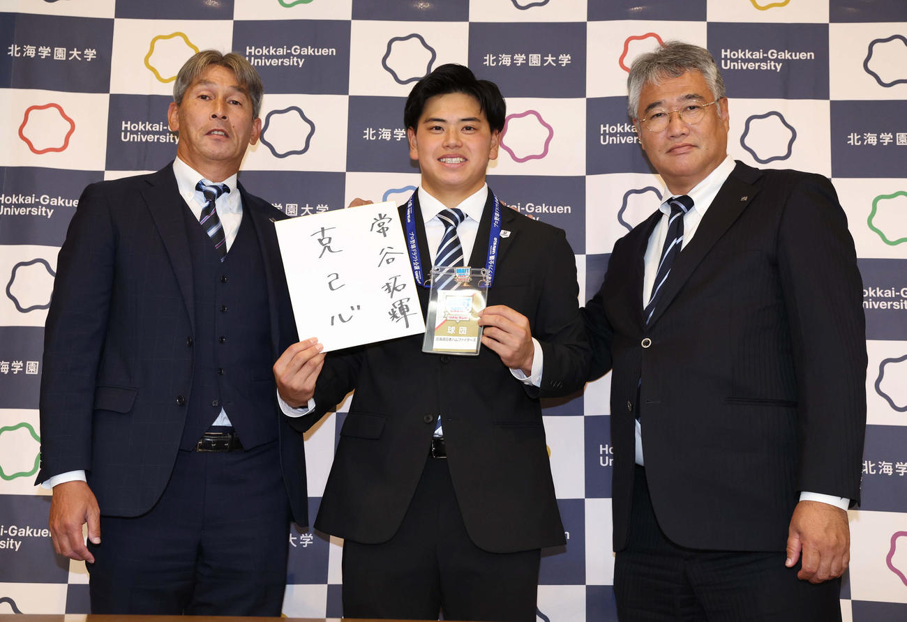 日本ハム育成1位指名された常谷は、指名あいさつで色紙に「克己心」と書く。左は白井スカウト、右は木田GM代行（撮影・黒川智章）
