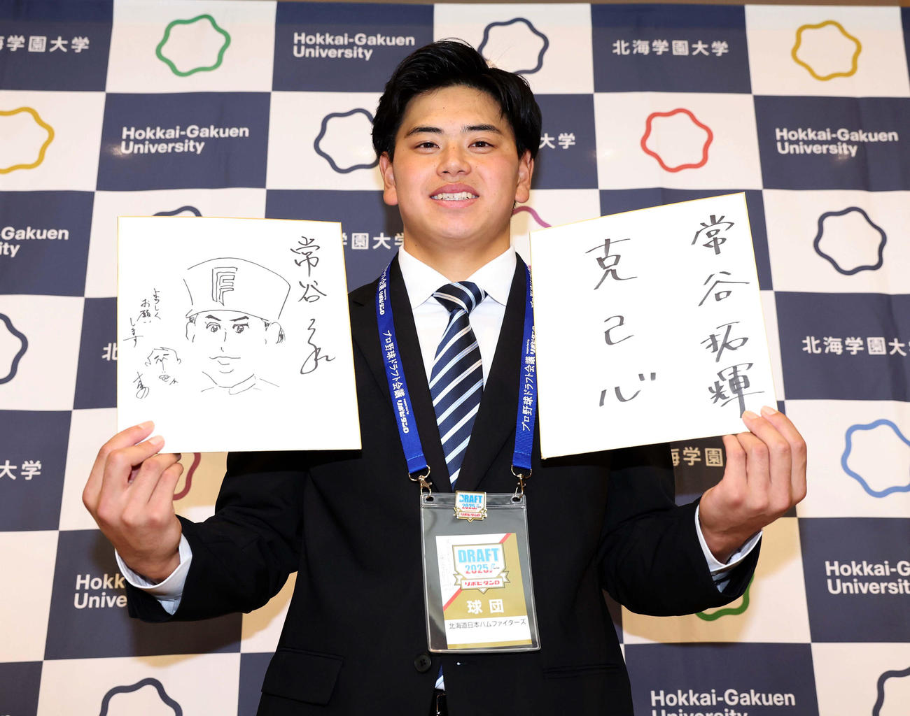 日本ハム育成1位指名された常谷は、指名あいさつで木田GM代行から似顔絵のプレゼントをされ笑顔を見せる（撮影・黒川智章）